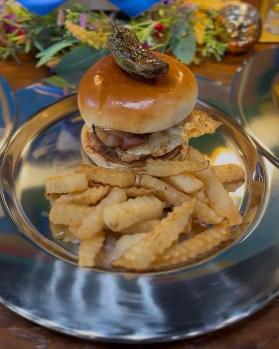 A Mexican Burger topped with a roasted jalapeño, with crinkle-cut fries.
